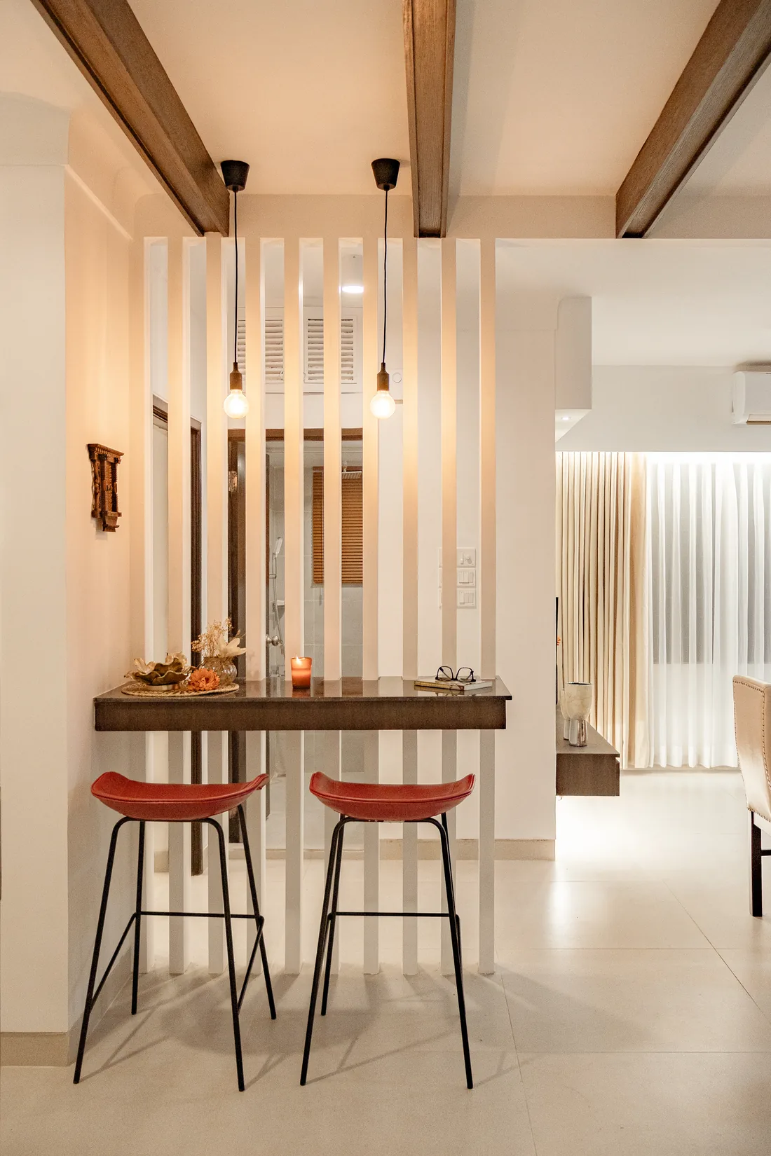 A slim breakfast counter with red stools in the Baridhara DOHS residence