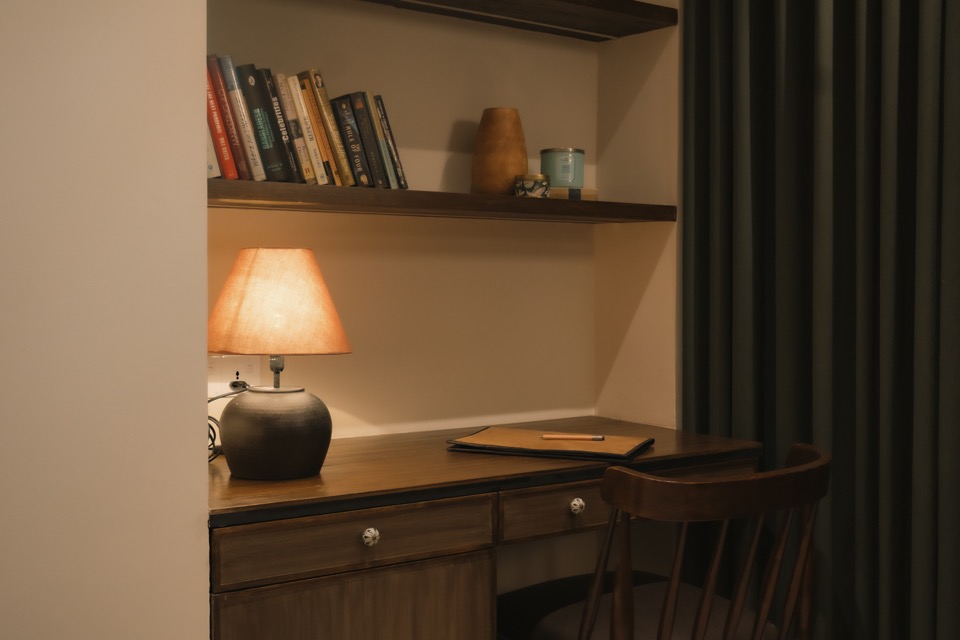 Reading desk and shelving beside a deep green curtain