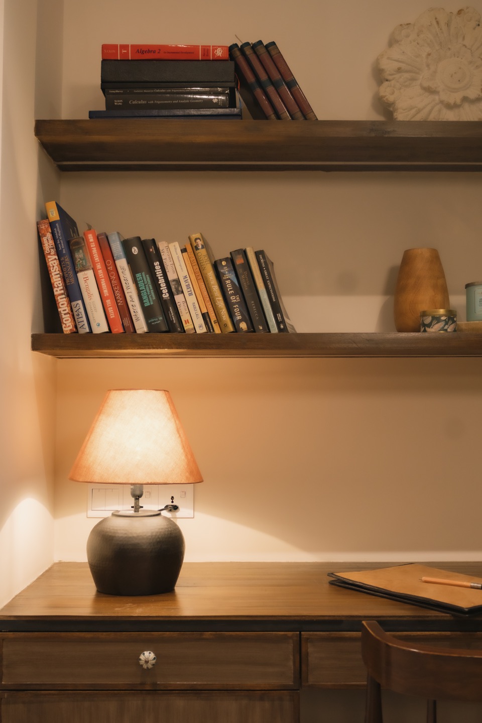 Warm lamp illuminating books and a vintage writing desk