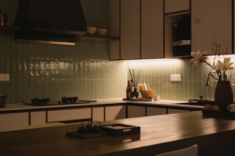 Sage tile, pale cabinetry and timber dining surface in the kitchen
