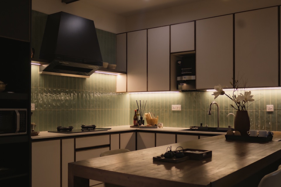Kitchen counter and green backsplash beneath timber ceiling beams