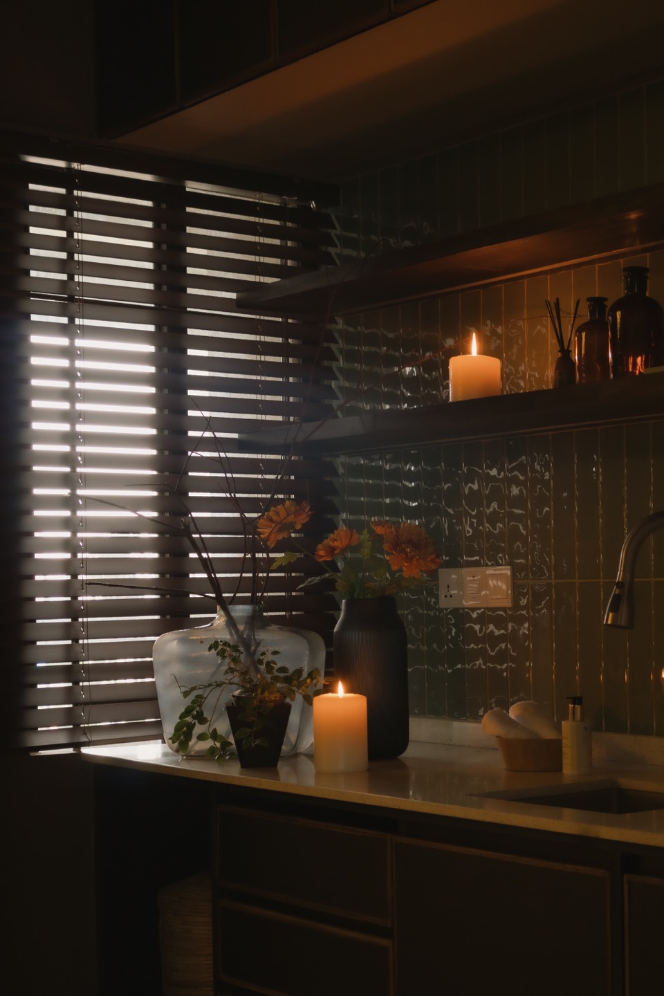 Candlelit laundry shelves behind timber and rattan