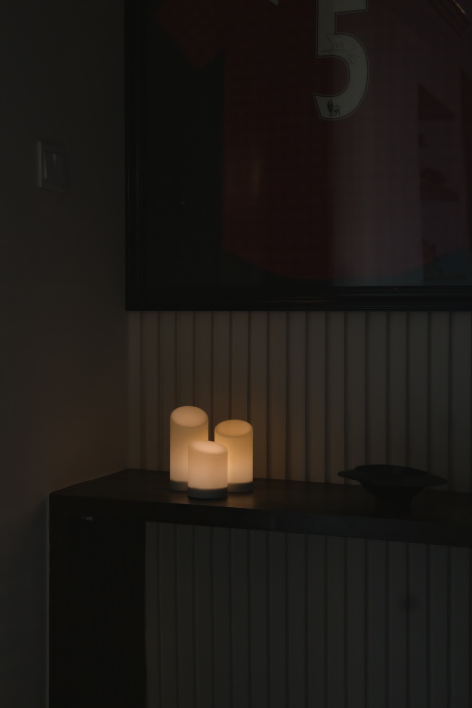 Framed sports jersey displayed in a dark living-room niche