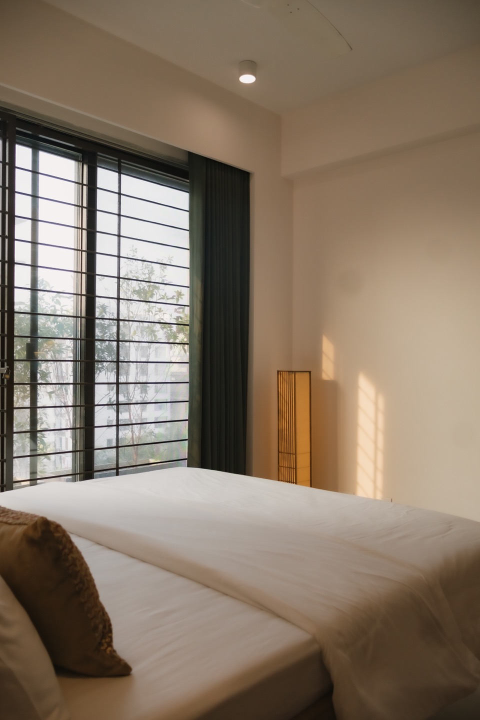Second bedroom receiving daylight through broad windows