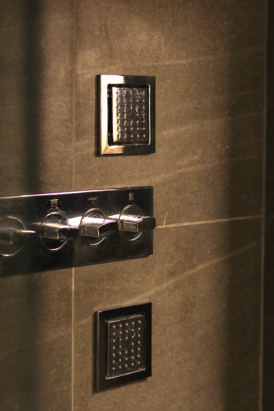 Black shower fittings set against tactile grey tile