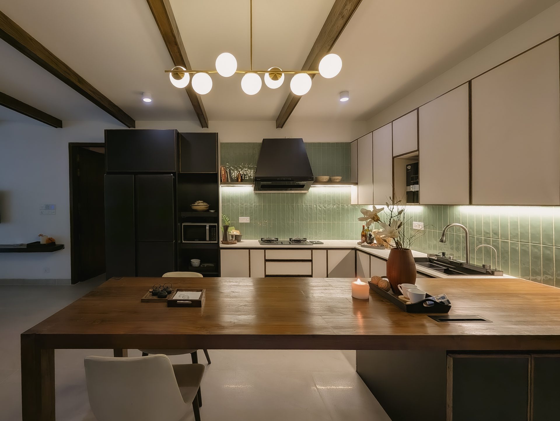Open kitchen with pale cabinetry and a long integrated timber dining table