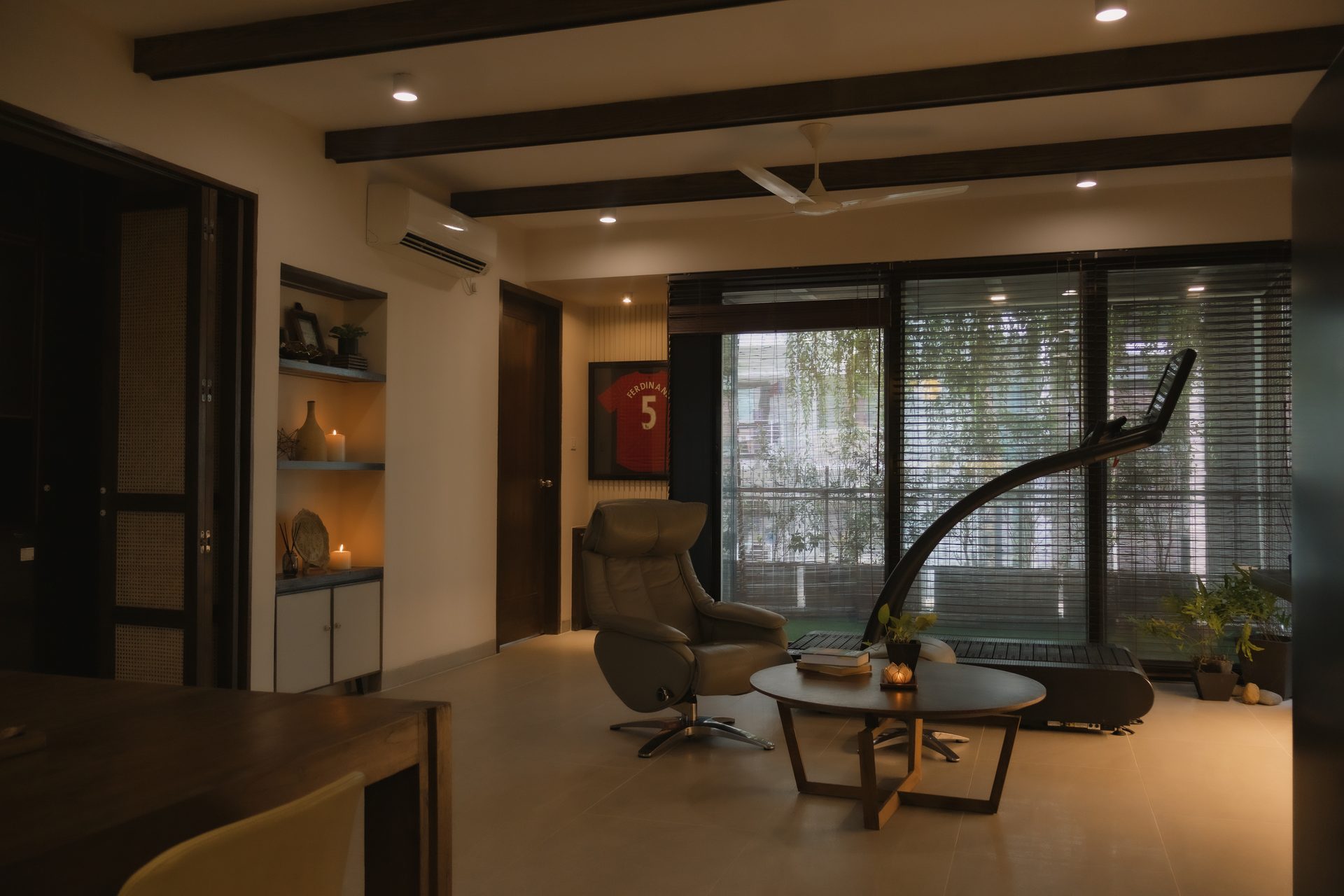 Open lounge with a reclining chair, exercise equipment and garden-facing windows