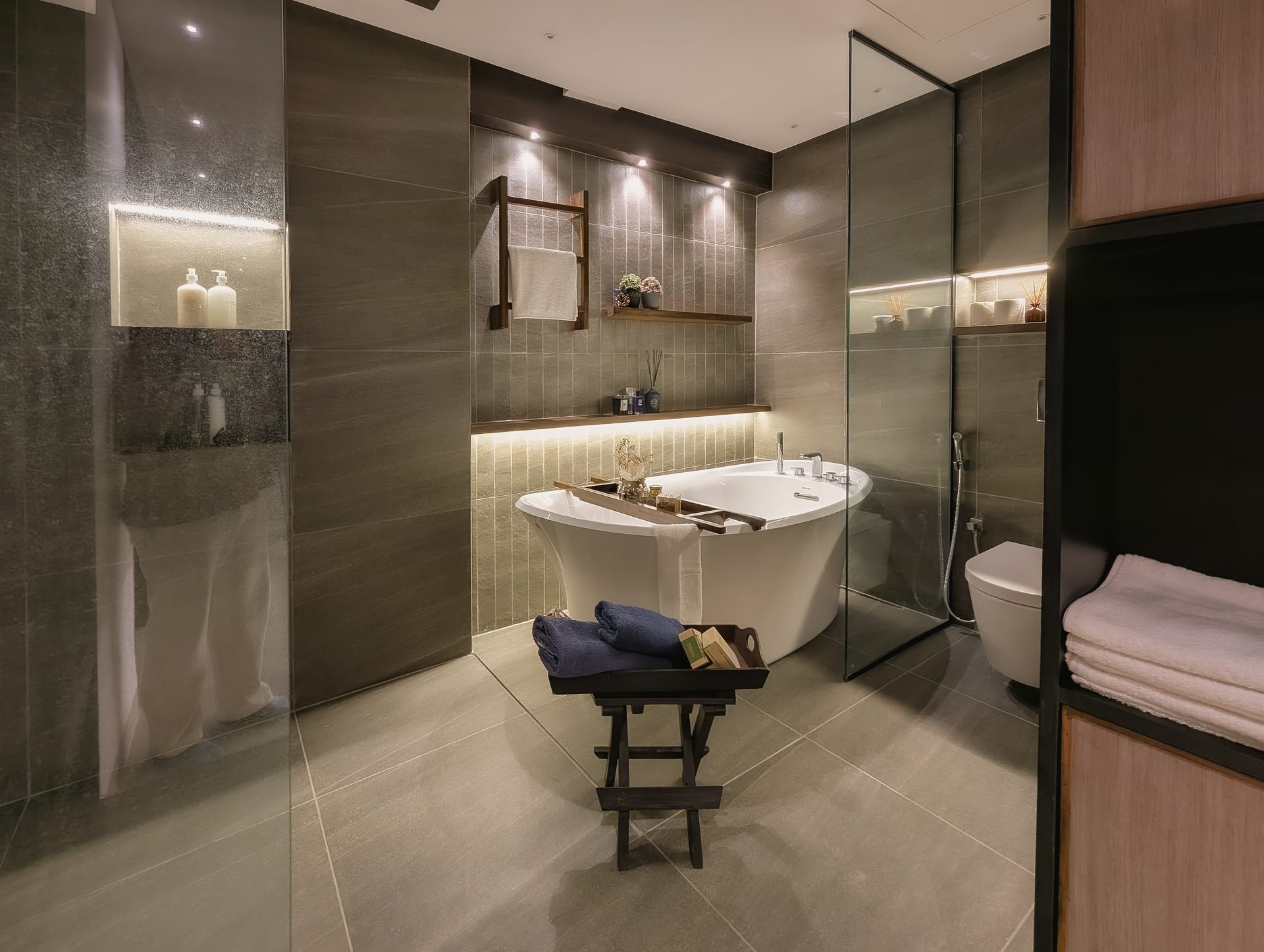 Wide view across the freestanding bath, shower and warm illuminated ledges