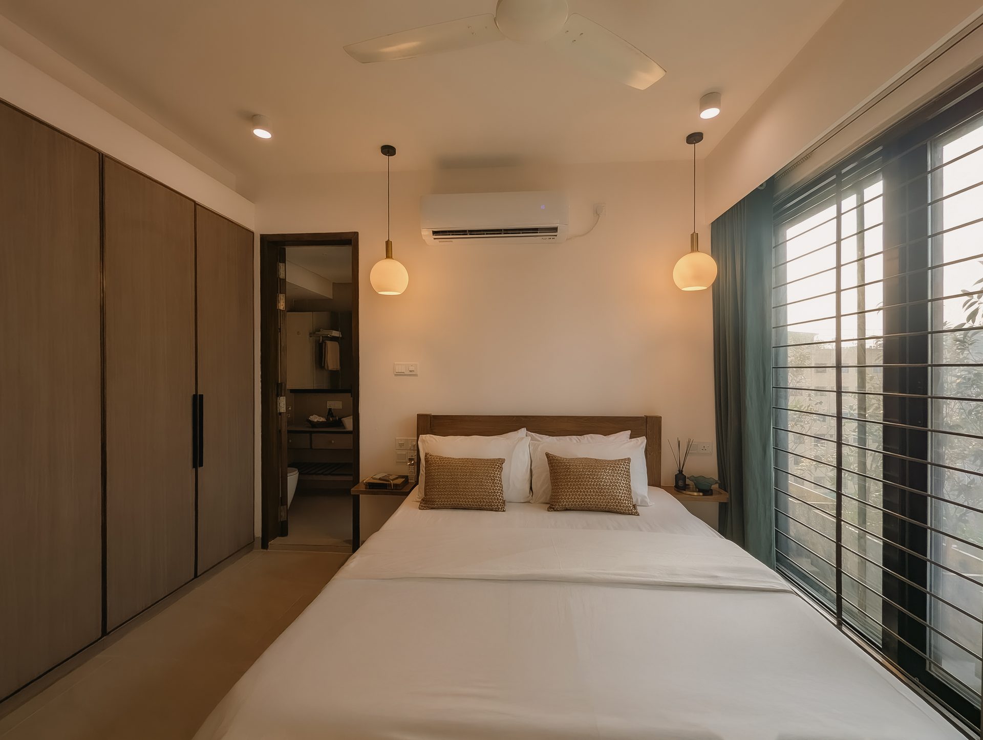 Second bedroom viewed toward its full-height wardrobe and broad windows