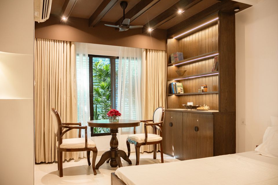 Reading nook with a round table, restored chairs and integrated timber shelves