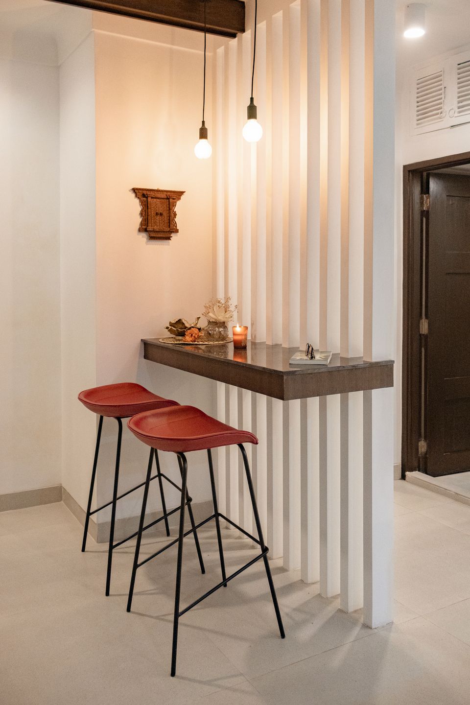 Marble breakfast counter with red stools and vertical louvers