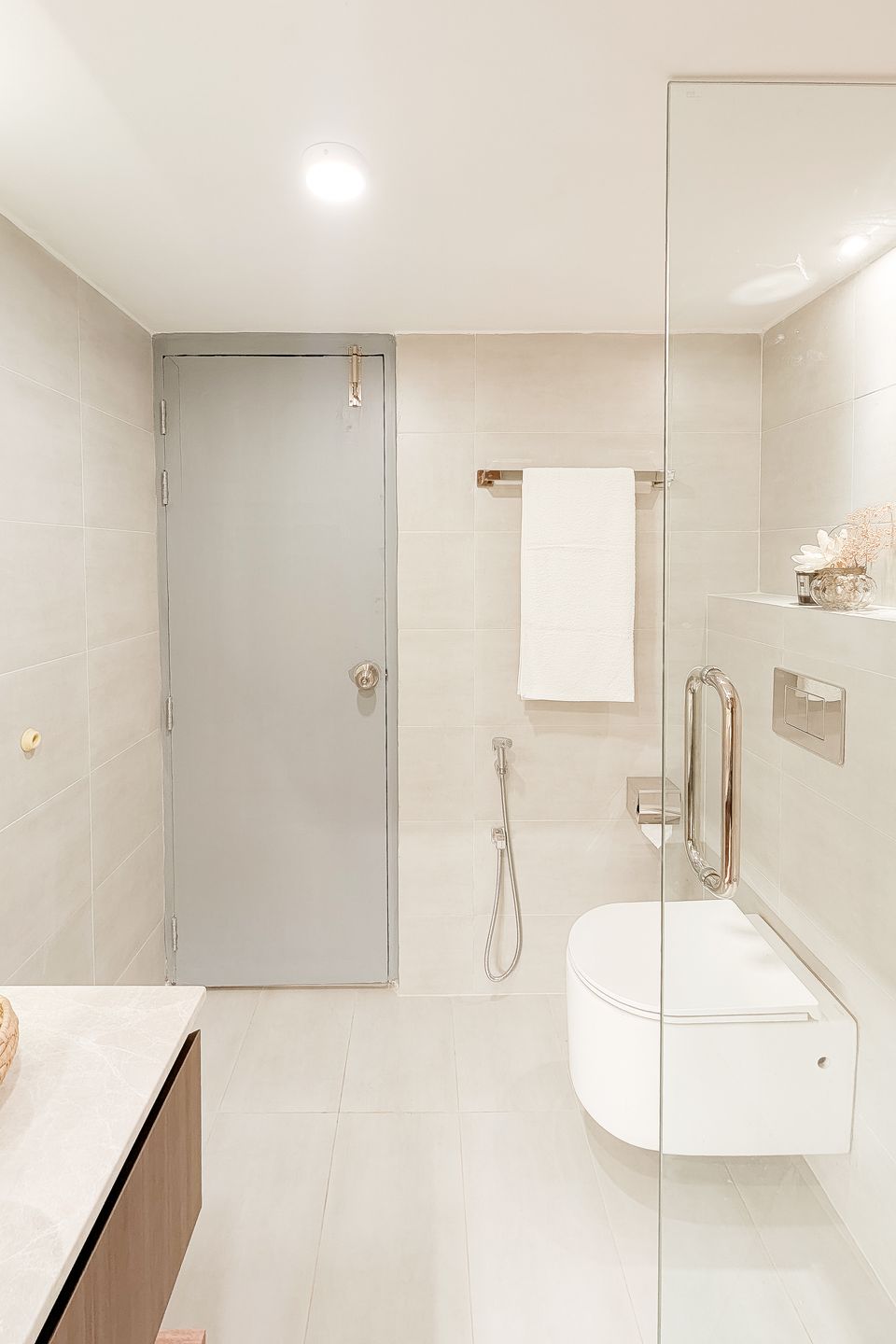 Bathroom shower with pale stone tile and glass screen