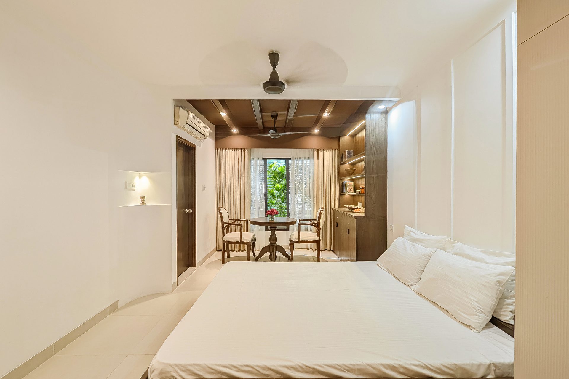 Minimal bedroom opening toward a timber-lined reading nook