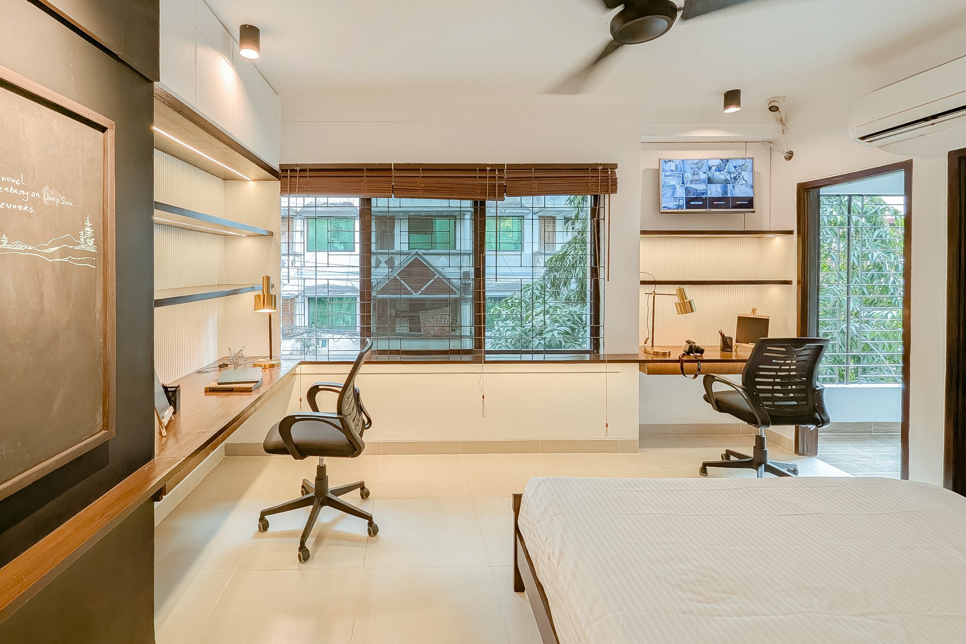 Shared bedroom with two study desks arranged around a broad window