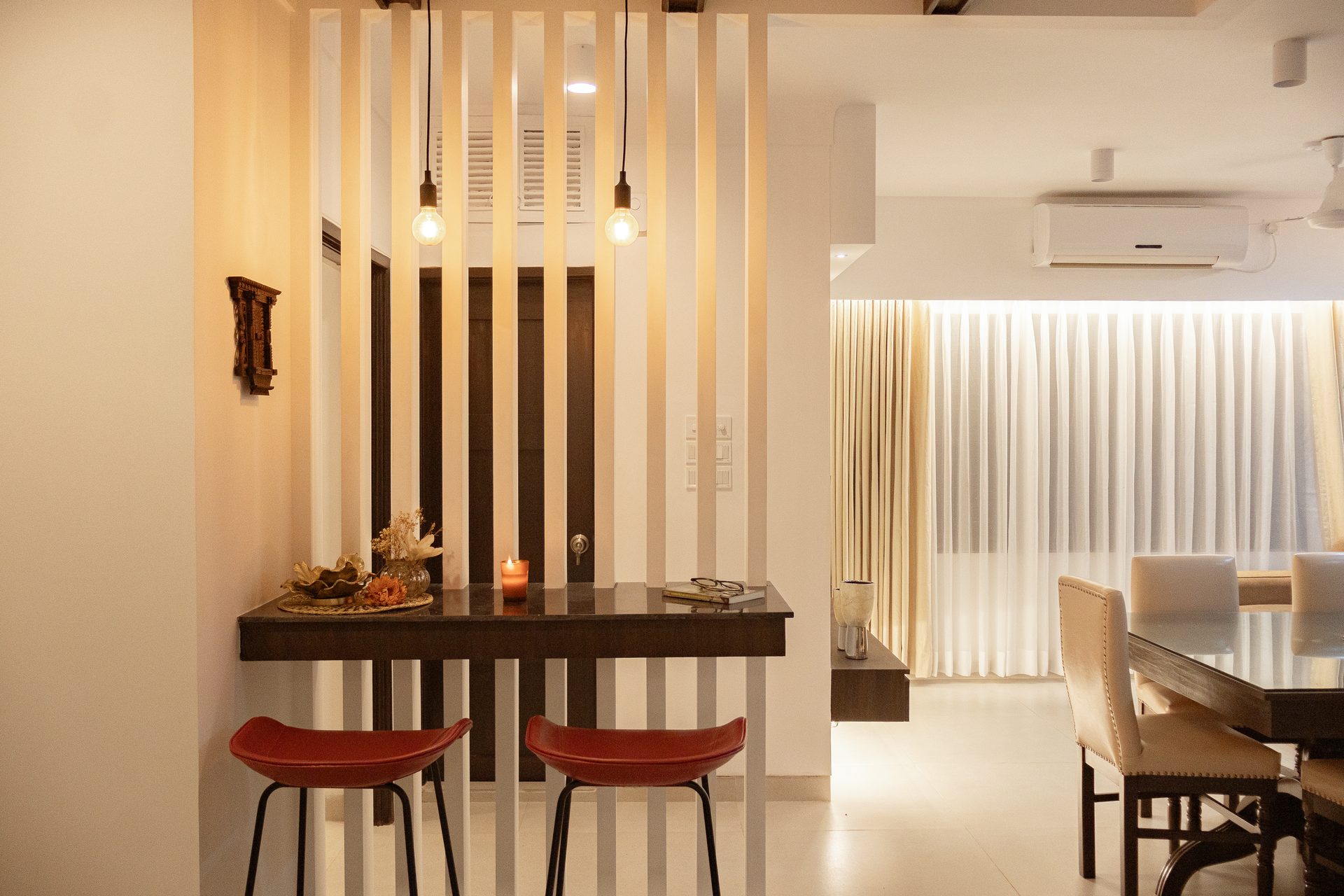 Marble breakfast counter with red stools against vertical louvers