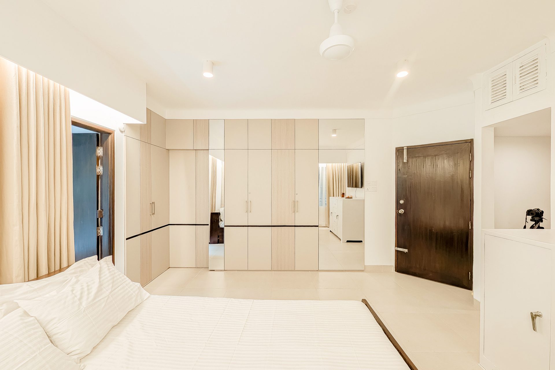 Full-height pale storage and television cabinet in the guest room