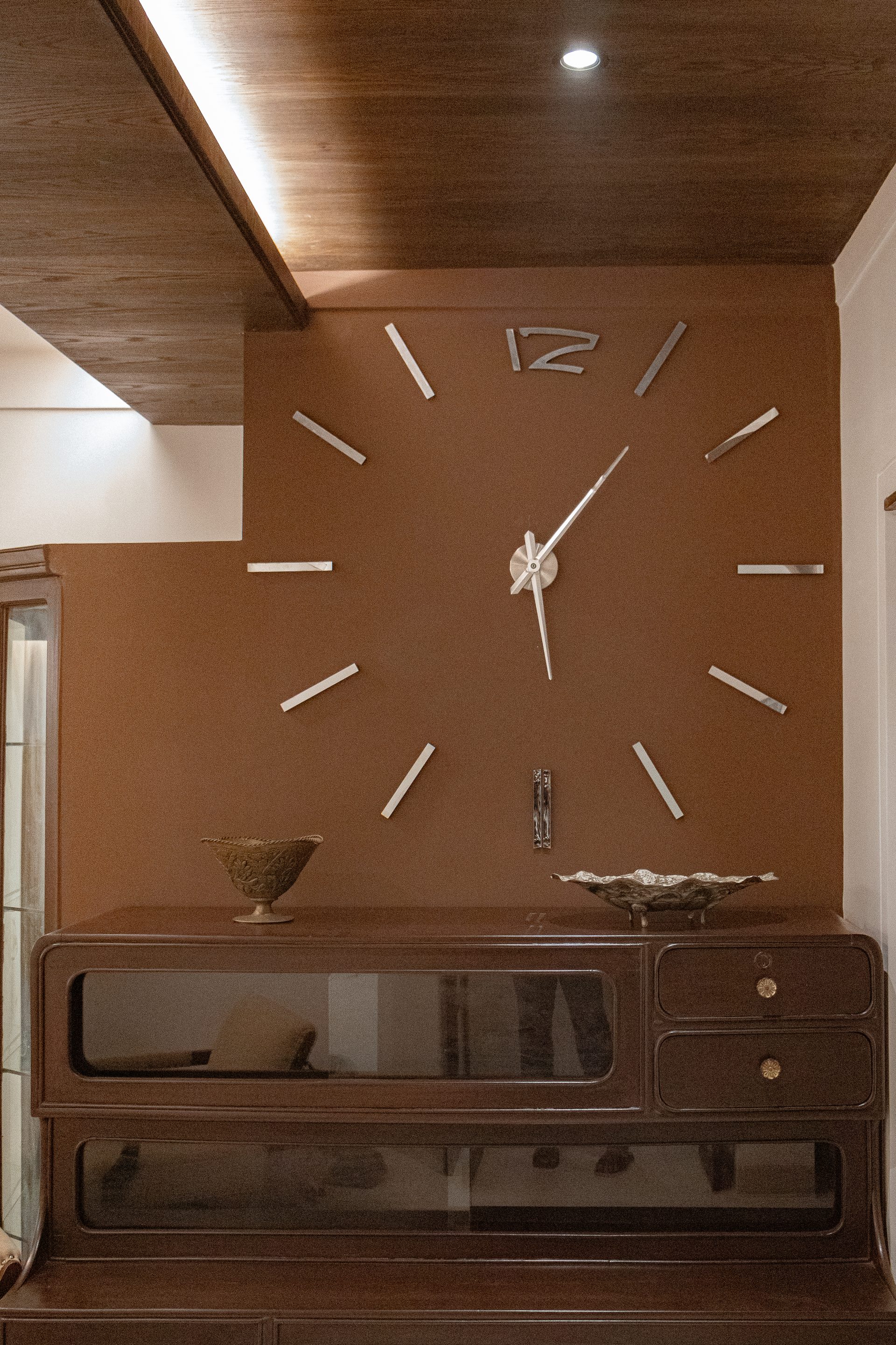 Preserved wall clock displayed against a warm brown feature wall