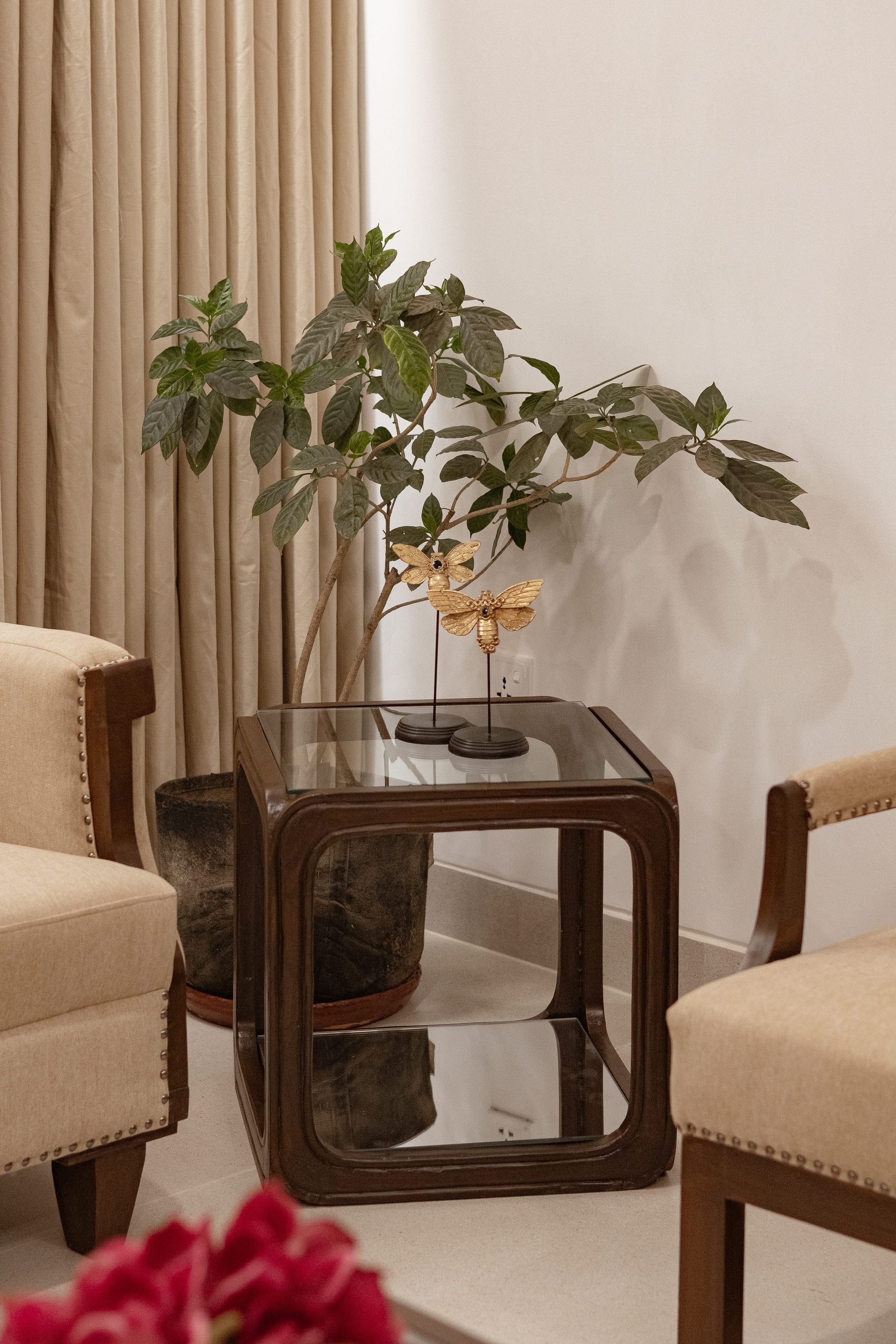Refinished side table and upholstered chair beside indoor planting
