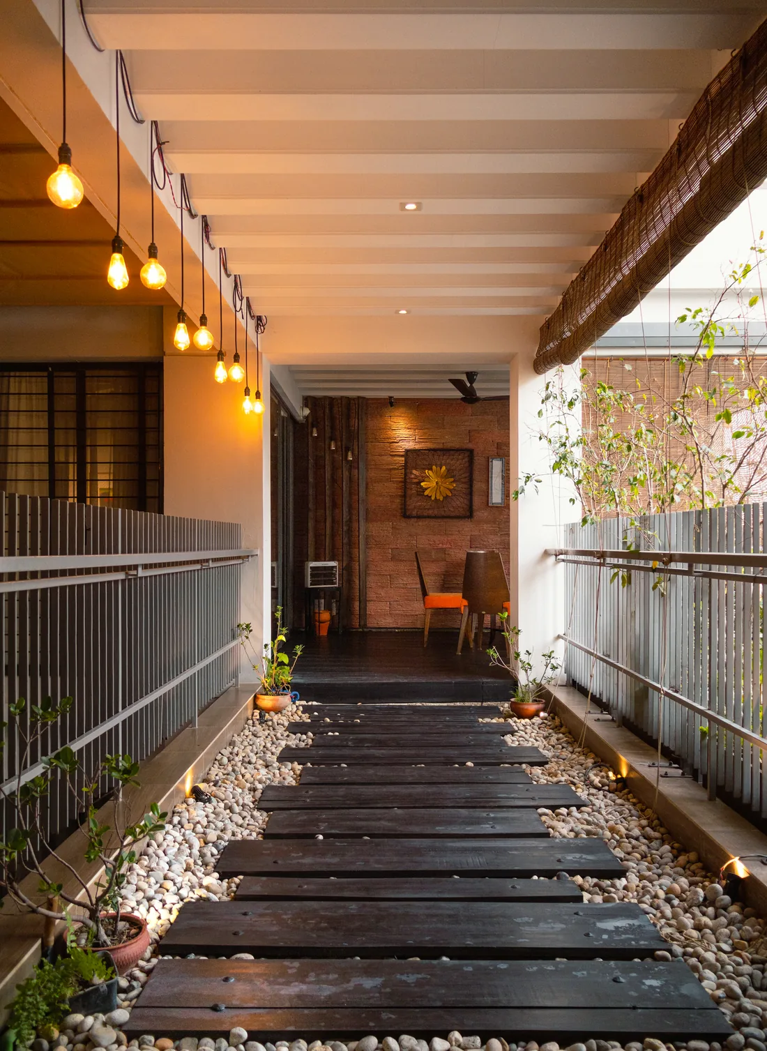 A timber garden pathway lined with river stones and plants at Verdant Hideaway